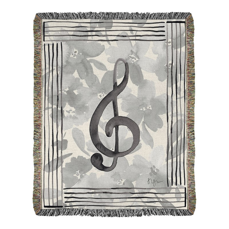 Woven blanket with a treble clef design on a floral background