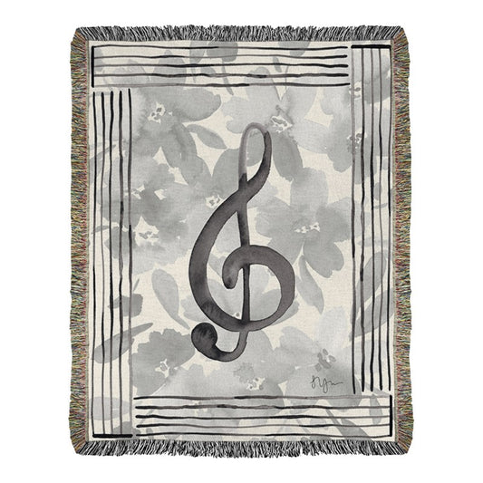Woven blanket with a treble clef design on a floral background